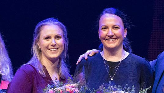 Bilde av smilende prisvinnere: Marianne Hestholm og Stine Lampe, flankert av helsebyråd Ruth Grung og konferansier Samuel Massie. 