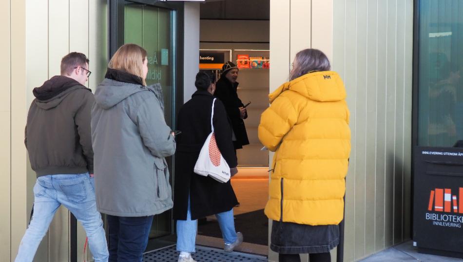 Folk bruker inngangen for meråpent på Åsane bibliotek