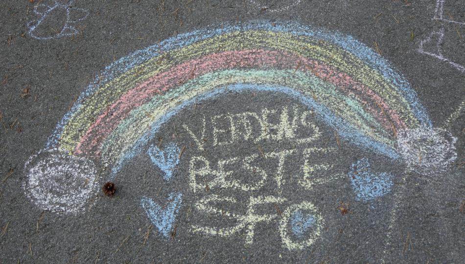 Kritt på asfast med tegning av regnbue og teksten verdens beste SFO. 
